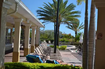 a group of people laying on lounge chairs at a resort at Lake Front Huge by clubhouse in Orlando