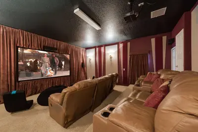 a living room with a couch and a flat screen tv at Enchanted Villa Oasis in Orlando