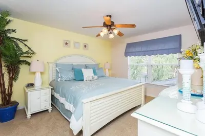 a bedroom with a bed and a ceiling fan at Enchanted Villa Oasis in Orlando