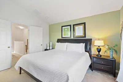 a bedroom with a large bed with a white bedspread at 2563 Maneshaw in Orlando