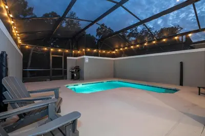 a swimming pool in the middle of a patio with lights at Amazing Disney resort style & FREE Waterpark 2481 in Kissimmee