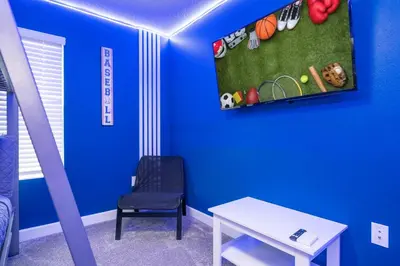 a room with a blue wall with a chair and a table at Disney adventure resort style free waterpark2633 in Kissimmee