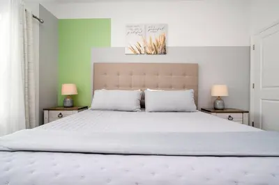 a bedroom with a large white bed with two lamps at Lake view & Free Resort Access near Disney 4399 in Kissimmee