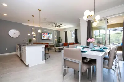 a dining room and living room with a table and chairs at Stylish home Near Disney Free Waterpark 4407 in Kissimmee