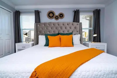 a bedroom with a large bed with orange pillows at Stylish home Near Disney Free Waterpark 4407 in Kissimmee
