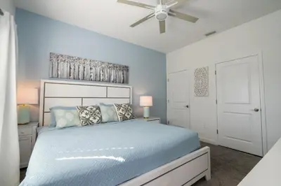 a bedroom with a blue bed and a ceiling fan at Cozy home Near Disney Free resort Access 4463 in Kissimmee