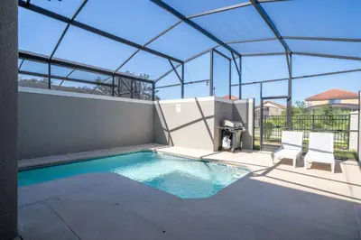 a swimming pool in a building with two chairs at Cozy home Near Disney Free resort Access 4463 in Kissimmee