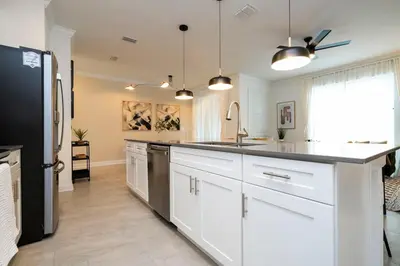 a kitchen with white cabinets and a black refrigerator at Pro decor Disney Resort style FREE Waterpark 4467 in Kissimmee