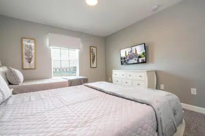 a bedroom with a bed and a tv on the wall at lion king affordable home & free waterpark 4913 in Kissimmee