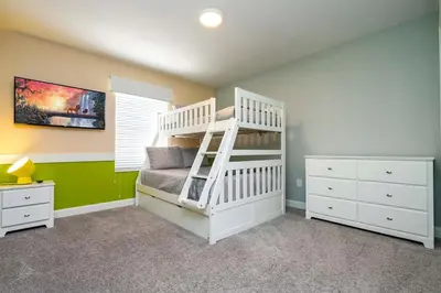 a bedroom with a bunk bed with a ladder at lion king affordable home & free waterpark 4913 in Kissimmee