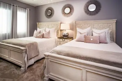 two beds in a bedroom with two mirrors on the wall at Gorgeous Vacation Home near Everywhere in Kissimmee