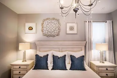 a bedroom with a bed with blue pillows and a chandelier at Gorgeous Vacation Home near Everywhere in Kissimmee