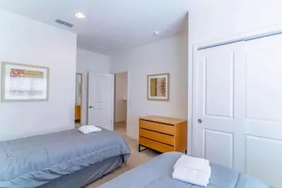 a bedroom with two beds and a closet and a door at Private Spa Townhome at Regal Oaks Resort in Orlando