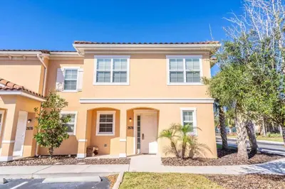 a large house with trees in front of it at Private Spa Townhome at Regal Oaks Resort in Orlando