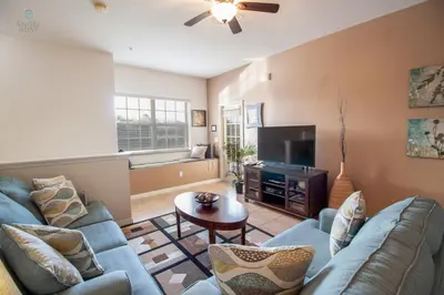 a living room with two blue couches and a television at Townhome at Oakwater Resort in Orlando