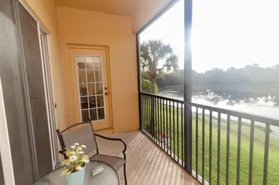 a balcony with a chair and a large window at Townhome at Oakwater Resort in Orlando