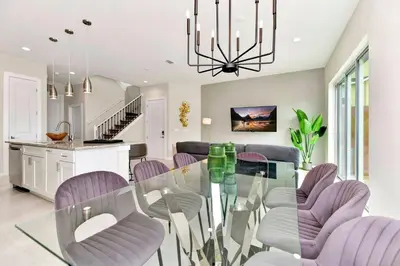 a dining room with a glass table and purple chairs at New Towhouse 2025 in Orlando