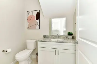 a white bathroom with a toilet and a sink at New Towhouse 2025 in Orlando