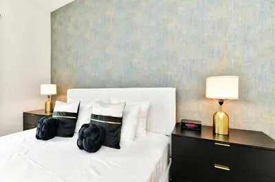 a bedroom with a white bed with two lamps on it at New Towhouse 2025 in Orlando