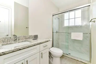 a bathroom with a toilet and a glass shower at New Towhouse 2025 in Orlando