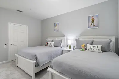 two beds in a bedroom with white walls at 7671 Comrow Unit 205 in Kissimmee