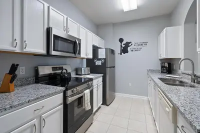 a kitchen with white cabinets and black appliances at 7671 Comrow Unit 205 in Kissimmee