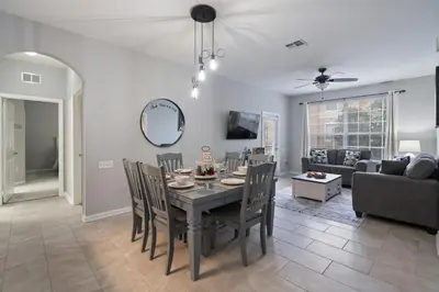 a dining room and living room with a table and chairs at 7671 Comrow Unit 205 in Kissimmee