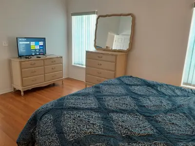 a bedroom with a bed and a dresser with a mirror at Three-Bedroom House in Clear Creek in Orlando