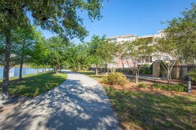 a path through a park with trees and a building at Apartment at Vista Cay Resort in Orlando