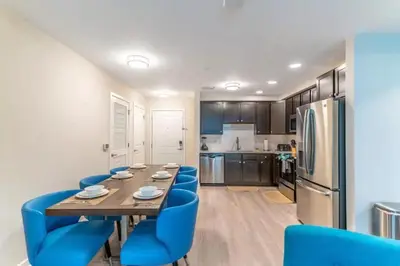 a kitchen with a long table and blue chairs at Apartment at Vista Cay Resort in Orlando