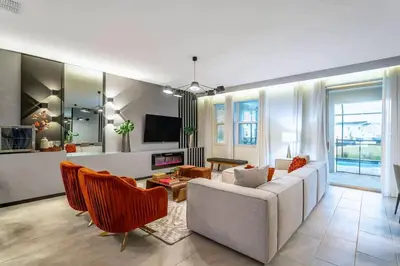 a living room with a white couch and orange chairs at Private Pool and Spa Home at Storey Lake Resort in Kissimmee