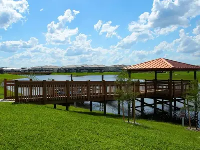a wooden bridge over a river with a gazebo at Private Pool and Spa Home at Storey Lake Resort in Kissimmee