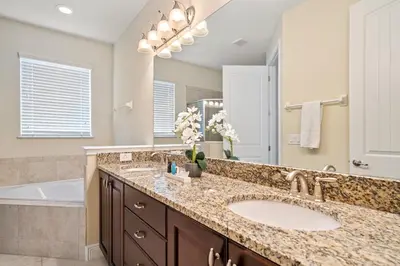 a bathroom with a large sink and a tub and a tubermottermott at 11 bd home Movie Room Close to Disney Sleeps 24 in Orlando