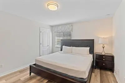 a bedroom with a bed and a lamp and a window at 8960 Cat Palm Road in Kissimmee