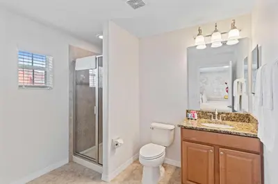 a bathroom with a toilet and a sink and a shower at 8960 Cat Palm Road in Kissimmee