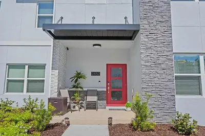 a red door on a white building with a brick wall at 2452 Reading Trail in Kissimmee