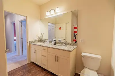 a bathroom with a sink and a toilet and a mirror at New in the market townhouse in West Lucaya! in Kissimmee