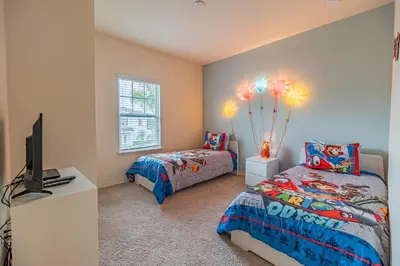 a bedroom with a twin bed and a television at New in the market townhouse in West Lucaya! in Kissimmee