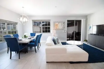 a living room with a white couch and a table at Private Pool Townhome at Storey Lake Resort in Kissimmee