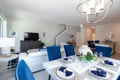a living room with a table and blue chairs at Private Pool Townhome at Storey Lake Resort in Kissimmee