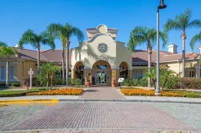 a building with palm trees in front of a street at Apartment at Vista Cay Resort in Orlando