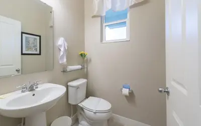 a white bathroom with a sink and a toilet at Townhome at Compass Bay Community in Kissimmee