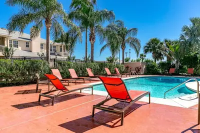 a group of chairs sitting next to a swimming pool at Townhome at Compass Bay Community in Kissimmee