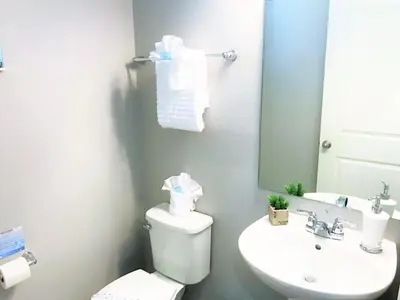 a bathroom with a toilet and a sink and a mirror at Townhome at Compass Bay Community in Kissimmee