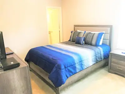 a bedroom with a bed with blue sheets and a laptop at Townhome at Compass Bay Community in Kissimmee