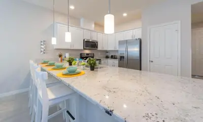 a kitchen with a counter with chairs and a refrigerator at Townhome at Compass Bay Community in Kissimmee