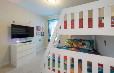 a white bunk bed in a room with a tv at Townhome at Compass Bay Community in Kissimmee