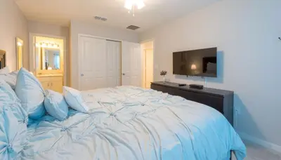 a large bed with blue pillows in a bedroom at Townhome at Compass Bay Community in Kissimmee