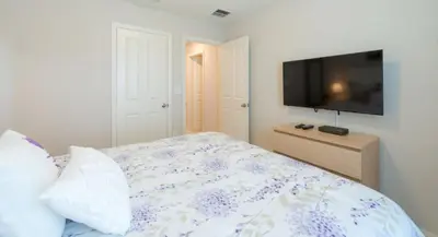 a bedroom with a bed and a flat screen tv at Townhome at Compass Bay Community in Kissimmee