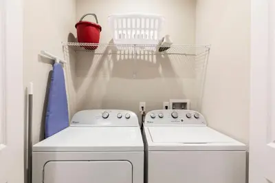 a laundry room with a washing machine and a shelf at Fantastic 4 beds Villa 5 min to Disney in Orlando